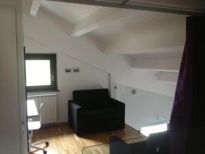 a living room with a black chair and a window at Villa Parco La Collina in Alfedena