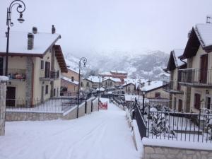 una calle cubierta de nieve en una ciudad con edificios en Villa Parco La Collina, en Alfedena