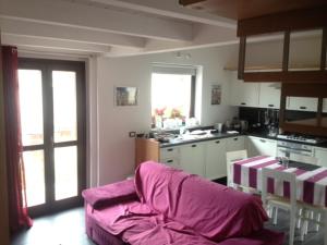 sala de estar con sofá púrpura en la cocina en Villa Parco La Collina, en Alfedena
