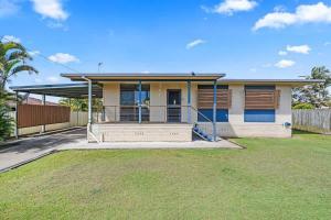 a house with a large yard in front of it at Coastal Cottage in Urangan +16 photos