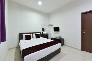 Un dormitorio con una cama grande y un televisor. en Hotel O Melaka near AEON Shopping Centre formerly Formosa, en Malacca