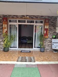 a patio with two potted plants in front of a building at Le Passager Cilaos maison privée in Cilaos