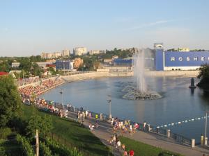 a group of people walking around a pond with a fountain at Apartment For Guests with Soul in Vinnytsya