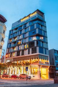 a tall building with cars parked in front of it at Tu Son Luxury Hotel in Bắc Ninh