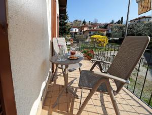 - Balcón con mesa pequeña y 2 sillas en Vitali Apartments Bellagio, en Bellagio