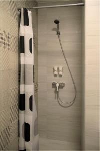 een douche met een zwart-wit douchegordijn in de badkamer bij Solo Apartment Ahmatovoy in Kiev