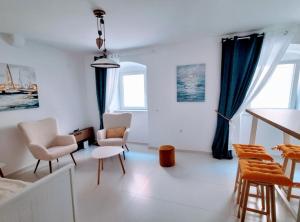- un salon avec des murs blancs et des rideaux bleus dans l'établissement La Casa Nostra Apartments, à Senj