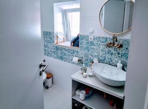 une salle de bain avec un lavabo et un miroir dans l'établissement La Casa Nostra Apartments, à Senj