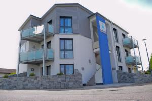 a large white building with a blue door at SK Apartments -Apartment mit 2 Schlafzimmern in Rust