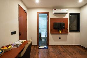 een woonkamer met een tafel en een televisie en een kamer bij Aarchh Regency Noida in Noida