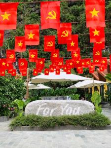a bunch of chinese flags flying in front of a wall at For You Ninh Bình Boutique in Ninh Binh