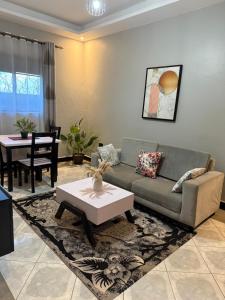a living room with a couch and a table at Fivas Residences in Arua