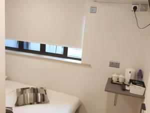 a white room with a bed and a window at Goodrich Hotel in Hong Kong