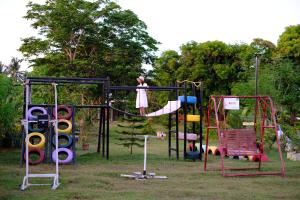 a girl is on a swing set in a park at Camp Felicidad in Talisay