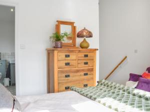 a bedroom with a dresser with a mirror on it at Kestrel Cottage in Holmbridge