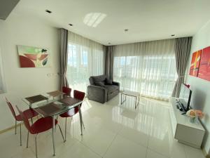 a living room with a table and chairs and a couch at The Gallery Condominium M in Jomtien Beach