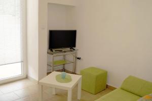 a living room with a tv and a couch and a table at Apartments Kuća Grško in Selce
