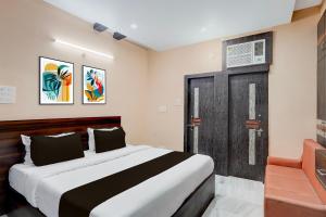 a bedroom with a bed and a wooden door at Super Collection O Patliputra Sports Complex Formerly Wellfood Inn in Patna +22 photos