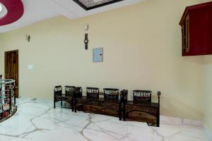 a room with two benches against a white wall at Hotel O NIMS Hospital Formerly White Castle in Bālarāmpuram