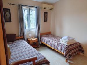 a bedroom with two beds and a window at Lacaz Vacances in Tamarin