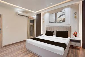 a bedroom with a large white bed and a window at Super Hotel O Rudrapur Railway Junction Formerly Krish in Rudrapur +24 photos
