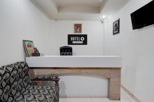 a living room with a fireplace and a chair at Super Hotel O Rudrapur Railway Junction Formerly Krish in Rudrapur
