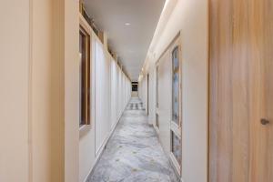 a hallway with white walls and a tile floor at Super Hotel O Rudrapur Railway Junction Formerly Krish in Rudrapur
