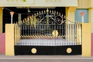a black and gold gate in front of a building at Hotel O Kelambakkam Bus Terminal Formerly Guna Residency in Kelambākkam