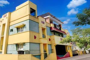 a colorful building on the side of a street at Hotel O Kelambakkam Bus Terminal Formerly Guna Residency in Kelambākkam +34 photos