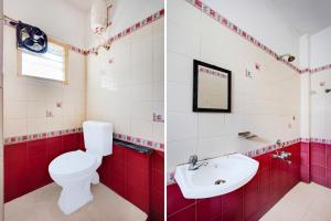 a red and white bathroom with a toilet and a sink at Hotel O Kelambakkam Bus Terminal Formerly Guna Residency in Kelambākkam