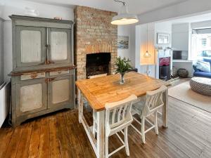 a kitchen with a wooden table and a fireplace at Sweet Victoria in Whitstable