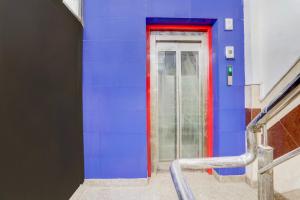 a blue wall with a red door in a building at Townhouse Johri Enclave Metro Station Formerly Second Home in New Delhi +49 photos