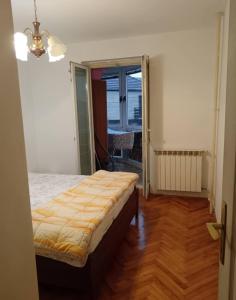 a bedroom with a bed in a room with a window at Stan in Kraljevo