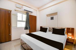 GulzārbāghにあるSuper Townhouse Kumhrar Archeological Park Formerly Hotel Karuna Palaceの大きなベッドと窓のある寝室