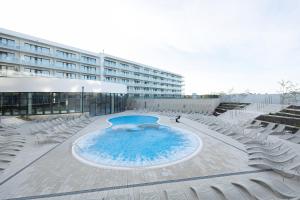 ein großes Schwimmbad vor einem Gebäude in der Unterkunft Polanki Aqua Stylowy Apartament 300 m od Plaży by Noclegi Renters in Radzikowo