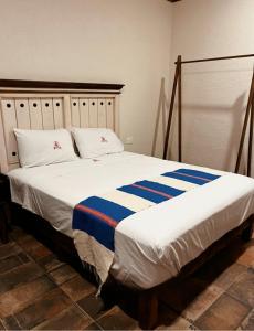 a bedroom with a large bed with blue and white sheets at Hotel Finca San José in Teotlalco