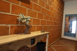 a flower in a vase sitting on a table against a brick wall at Hotel Finca San José in Teotlalco +18 photos