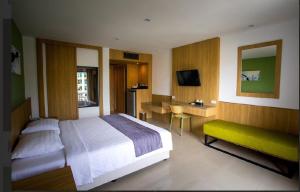 a bedroom with a bed and a desk and a television at Royal Palace Hotel in Pattaya Central