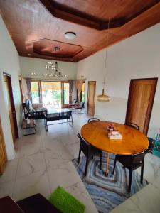 a living room with a wooden table and a couch at VidFauw Oasis Villa in Naamlong