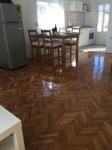 a kitchen with a wooden floor with a table and chairs at Centre Apartment Bozava in Božava