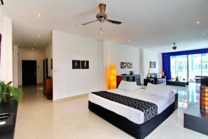 una camera con un grande letto e un ventilatore a soffitto di East Suites a Pattaya Sud