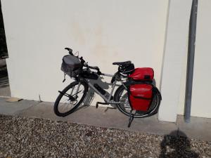 a bike parked against a wall with a red bag at les 3 notes de mérotte in Coutras