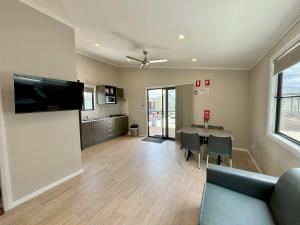 a living room with a couch and a table at Pacific Gardens Village in Heatherbrae