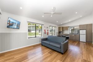 a living room with a couch and a kitchen at Pacific Gardens Village in Heatherbrae