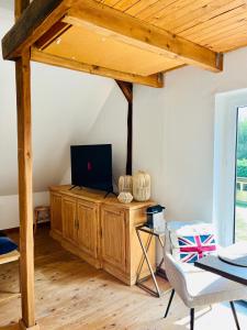 Una sala de estar con un televisor sobre un mueble de madera. en b e d & a g e d e s i g n -large- wunderschönes Zimmer mit Bad - Rechnungserstellung für Geschäftsreisende & Firmen, en Hünxe