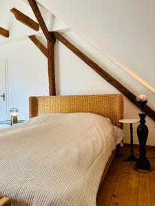 una cama en una habitación con vigas de madera en b e d & a g e d e s i g n -large- wunderschönes Zimmer mit Bad - Rechnungserstellung für Geschäftsreisende & Firmen, en Hünxe