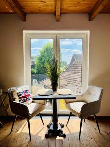 Una mesa y dos sillas en una habitación con ventana. en b e d & a g e d e s i g n -large- wunderschönes Zimmer mit Bad - Rechnungserstellung für Geschäftsreisende & Firmen, en Hünxe