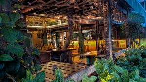 a restaurant with a bench and tables and plants at Villa Peray Siargao in General Luna