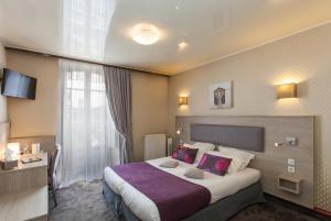 Cette chambre comprend un grand lit avec une couverture violette. dans l'établissement Cit'Hotel le Challonge, à Dinan