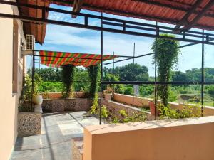 a patio with an umbrella and some plants at Maha Periyava Kuteeram 10 Adults Budget Stay in Kumbakonam
